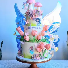 This is one of my special creations, a three-tier enchanted garden cake with mechanical moving butterfly wings. The cake is adorned with delicate sugar flowers, hand-painted details, and whimsical fairies, making it a truly interactive and magical centerpiece for a special birthday.
