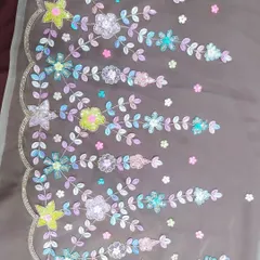 Here you can see the fine detail of a floral embroidery pattern up close. I chose a variety of colorful sequins and beads to move beyond basic metallics, creating a vibrant and modern design on a sheer fabric base.
