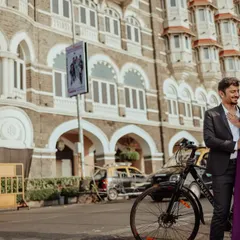 An elegant pose in front of the Taj Mahal Palace Hotel. The combination of a beautiful gown, a simple prop like a bicycle, and the grand hotel creates a chic, editorial-style photo.