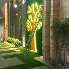 This is an example of a fully custom artificial green wall I designed. Using different shades and textures of artificial turf, I can create unique shapes and logos, like this stylized tree, to make a bold statement in any commercial or residential space.