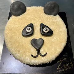 A simple yet charming panda face cake. This sculpted design uses a crumb-coat texture for fur and fondant details for the eyes, nose, and ears, creating a cute and minimalist animal cake.