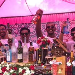 My team and I are always ready to bring the 'Funjabi' energy. Here we are, raising a glass (and a bottle) behind a bar decorated with dhols and flowers, all set for a high-energy celebration.