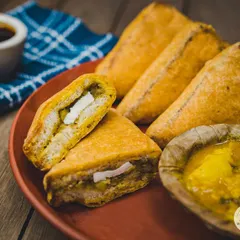 Our classic Bread Pakora, stuffed with a spicy potato and paneer filling. It's the perfect rainy day snack, served hot with our special chutneys.