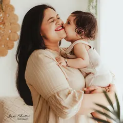 A candid moment of pure happiness as a baby gives her mom a cheerful kiss on the cheek. These are the unscripted memories that families will cherish forever.
