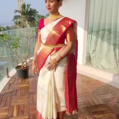 This bride opted for broader pleats for her wedding look, creating a bold and beautiful silhouette. Her white and red Kanjeevaram is a picture of classic South Indian bridal style.
