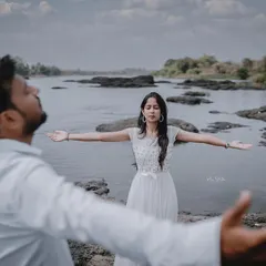 A creative shot inspired by a famous movie pose. This photo is fun, dramatic, and shows the couple's free-spirited nature against a beautiful riverside backdrop.