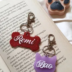 I make tags for cats and dogs. Here is a red glitter bone-shaped tag for 'Remi' and a lovely lavender cat-shaped tag for 'Bao'.