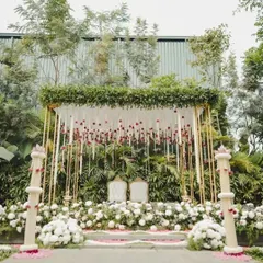 An elegant mandap setup featuring a canopy of hanging jasmine and rose garlands, creating a fragrant and visually delicate space for a traditional morning ceremony.