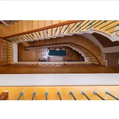 A view from the top of the winding staircase reveals the home's vertical connectivity and the beautiful curvature of its design, drawing the eye downwards through multiple levels.