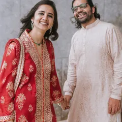 Capturing the happy smiles and connection of a couple during their engagement ceremony. The woman's vibrant red traditional outfit is absolutely stunning.