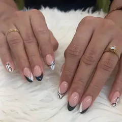 This artistic French manicure combines black and white tips with abstract swirl designs on an almond-shaped nail. It's a creative and stylish reinterpretation of a classic look.