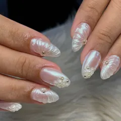 Inspired by the ocean. This design uses a pearly white base and sculpted gel to create a seashell-like texture, accented with tiny gold and pearl beads.