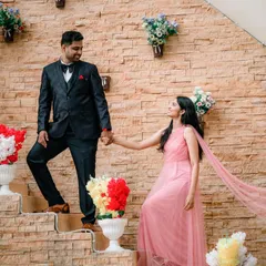 A classic pre-wedding pose with a romantic touch. The groom leads his bride-to-be up the stairs, her flowing pink dress adding a touch of elegance. This shot is all about capturing the connection and the journey you are starting together.