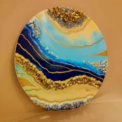 Adding a pop of color to your home decor with vibrant resin artwork. This abstract geode wall art in shades of blue, yellow, and gold makes a stunning statement piece for any room.