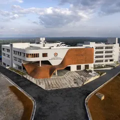 The Manipal School of Architecture & Planning, where the facade becomes a fluid, brick-clad gesture. This undulating form creates a welcoming, doorless entrance, tucking the main access below and allowing the steps to become a democratic space for student interaction.