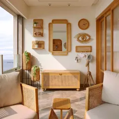 A full view of the cozy boho balcony, where every element is chosen to create a relaxed and stylish vibe. The rattan chairs, wooden chest, and wall decor all work together to make this the perfect spot to enjoy the sea breeze.