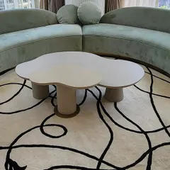 And here is the final product. The custom-designed, cloud-shaped center table sits perfectly on a modern rug, complementing the curved sofa and creating a soft, sculptural centerpiece for the living room.