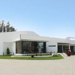 The Right-O' Food Court in Mandya, designed with a fluid and futuristic facade. The building's organic curves and large glass panels create an open and inviting space for travelers on the highway.