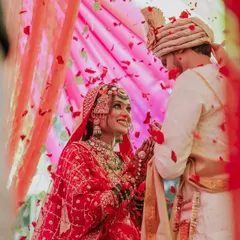 A perfect candid moment from a Maharashtrian wedding ceremony. I love capturing these genuine interactions, like the bride's joyful smile as flower petals rain down, creating a memory that feels as happy as the moment itself.