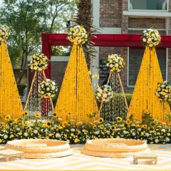 We believe a Haldi ceremony should be drenched in happiness and colour. This outdoor setup features towering cones of bright yellow marigolds, sunflower accents, and traditional seating, creating a picture-perfect scene for a sun-kissed celebration.