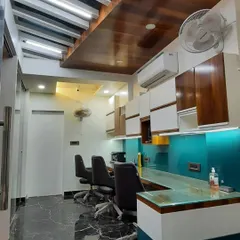 This image shows a functional staff workspace with a long counter, teal back-painted glass, and a combination of open and closed overhead storage. The wooden ceiling detail adds warmth to the sleek, modern design.
