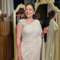 An elegant and sophisticated look in an ivory saree. The makeup is minimal and chic, with a simple diamond choker and a radiant smile.