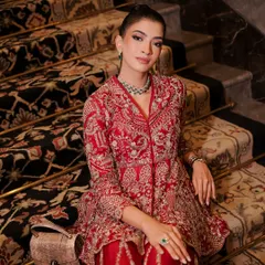 The full look, with the model seated on a grand staircase. The makeup is elegant and refined, a perfect match for the luxurious setting and couture outfit.