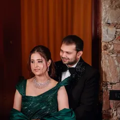 A romantic moment between the couple. The groom's classic black tuxedo perfectly complements the bride's glamorous green gown.