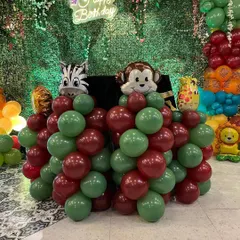 A close-up of the animal-themed decorations, with zebra and monkey foil balloons on top of balloon pillars.