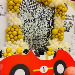 Full throttle for a first birthday with this "Fast One" racetrack theme. A shimmering sequin backdrop, balloon arches in gold and white, and a fun car cutout create an exciting and playful atmosphere for a little speedster's big day.