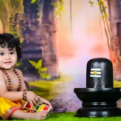 Another beautiful shot of the baby as a Shiva devotee, smiling and playing with a damaru.