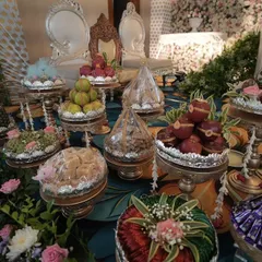A close-up of the engagement platters, showcasing an assortment of sweets, dry fruits, and decorative items presented in elegant silverware.