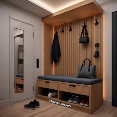This functional entryway design features a built-in bench with shoe storage cubbies below. A slatted wood panel with hooks offers a place for coats and bags, while overhead lighting ensures the space is bright and welcoming.