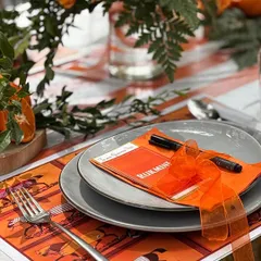 Another detail of the Hermès-themed table, showing the custom-printed placemat and elegantly tied napkin.