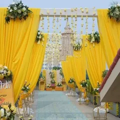 This is the entrance to a vibrant Haldi ceremony I decorated on a rooftop in Lodha. The bright yellow drapes, hanging floral strings, and fresh flower arrangements create a welcoming and festive atmosphere for the celebration.