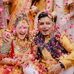 The Haldi ceremony is pure joy, and this shot is all about that infectious energy. Capturing the genuine laughter and fun as the couple gets showered with flower petals is what makes these moments unforgettable.