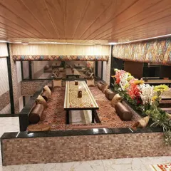 A view of my signature Dastarkhwan seating arrangement, with low tables, plush carpets, and comfortable cushions. This setup is designed to bring families and friends together for a traditional, shared meal.
