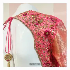 A Kanjeevaram saree blouse with a statement back design. The entire back panel is heavily embroidered with floral and peacock motifs in shades of pink and gold.