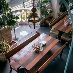 An overhead view of a table that holds more than just plates; it holds moments. The mix of wood, greenery, and antique lanterns creates a timeless setting for laughter and connection.