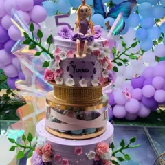 A close-up of a Rapunzel-themed butterfly cake for a 5th birthday. Notice the detailed floral decorations and the personalized name 'Yuvika' on the lavender frosting.