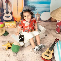 Who needs a real beach when you have the studio? This beach boy theme, complete with sand, surfboards, and a tiny guitar, is perfect for a fun and relaxed toddler shoot.