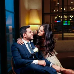 An intimate and romantic shot. The bride's glowing makeup looks beautiful even in the warm, ambient lighting, highlighting her radiant smile.