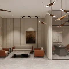This seating area within the Shilpa Rathna Clubhouse features clean lines and a balanced composition. A glass-walled meeting room provides a private space for discussions without visually closing off the lobby.