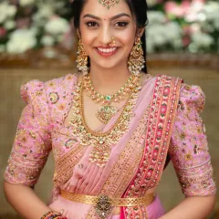 A closer look at the hand-embroidered puff-sleeve blouse designed to complement the Kanchi lehenga. The delicate floral embroidery on the blouse echoes the richness of the saree, creating a cohesive and personalized bridal ensemble.