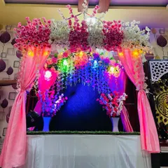This beautiful makhar setup features a theme of pink and white artificial cherry blossoms. The addition of pink drapes and colorful fairy lights creates a bright and cheerful atmosphere for the Ganpati festival.