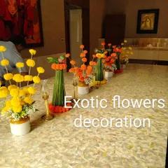An elegant table centerpiece arrangement for a festive meal. We used a series of small vases with marigold bouquets and leaf-wrapped stems, creating a beautiful runner down the length of the table.