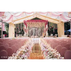 Inspired by the bride's Kanchivaram saree, this Muhurtham ceremony is a testament to our personalized design approach. The aisle is lined with a garden of roses leading to a magnificent floral mandap, all under a canopy of pink and white draped fabric, creating an atmosphere of regal elegance.