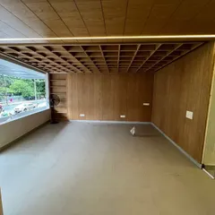 This is the welcome space for an institute in Koramangala, nearing completion. The extravagant waffle slab ceiling, clad in rich veneer, and the warm strip lighting create an inviting and unique first impression that is visible directly from the main road.