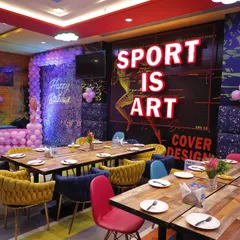 Our private party dining area set up for a celebration. The tables are arranged to be close to the action, with themed balloon decorations and modern, comfortable seating.