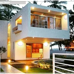 A contemporary villa designed for a compact plot in Bangalore. The structure uses a clean, minimalist aesthetic with strategic lighting that gives the home a warm, inviting glow after sunset, proving that modern design can also feel like a sanctuary.